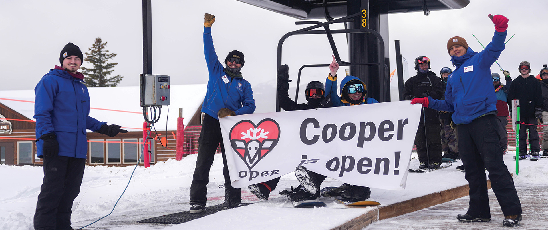 People holding the Cooper is Open banner
